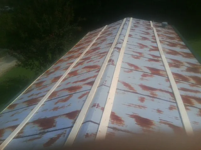 Rusted metal roof panels with new wood purlins before replacement — Storm Damage Roof Repair in Batesville by Roofing Brothers