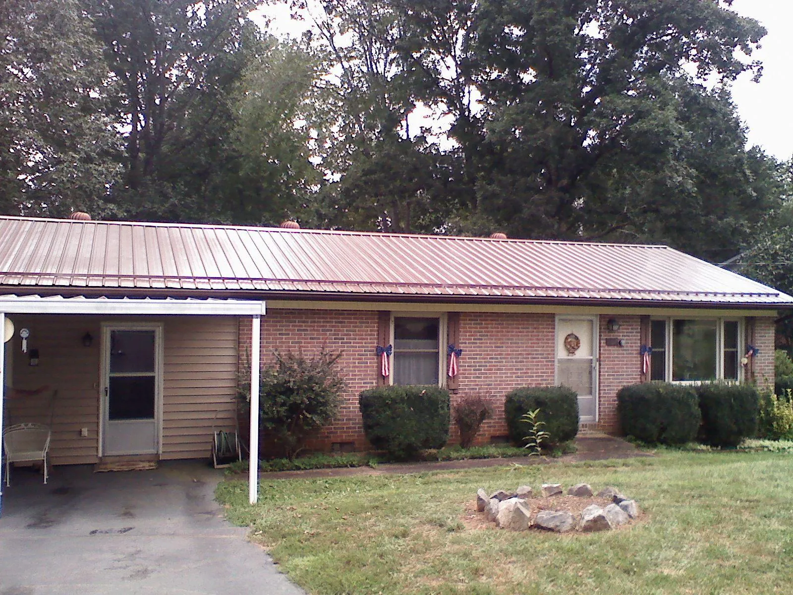 Bronze metal roof and carport on a brick ranch home — Roof Repair work by our crew in Batesville